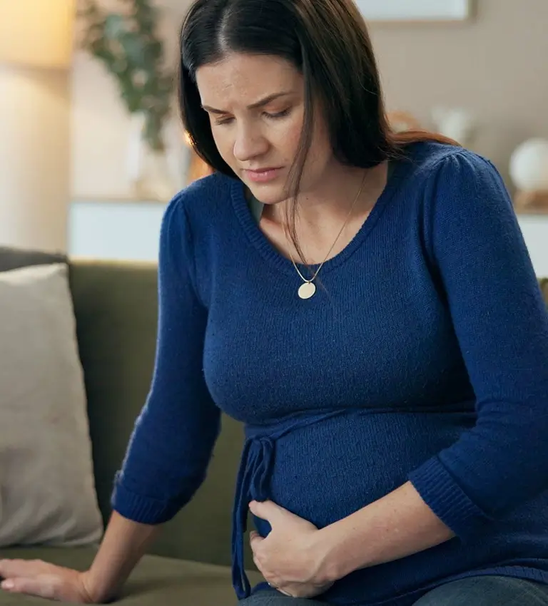 a pregnant woman sitting on a couch