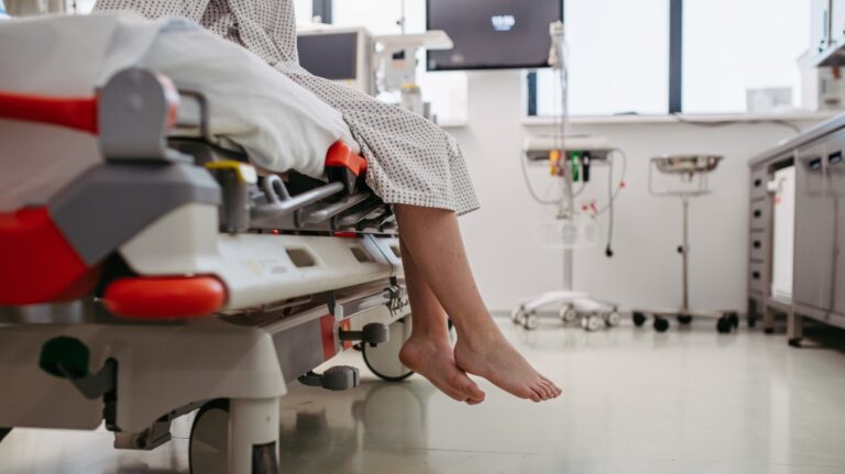 barefoot legs of patient, sitting on hospital bed