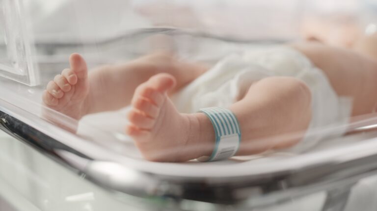 Newborn Baby Lying in Bassinet in a Maternity Hospital