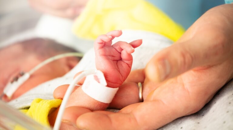 newborn hand and father fingers