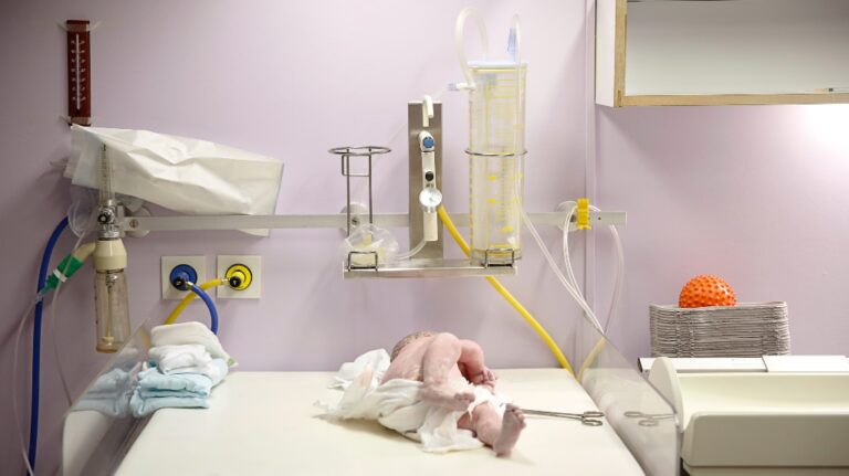 Maternity hospital delivery room, baby being assessed for apgar score