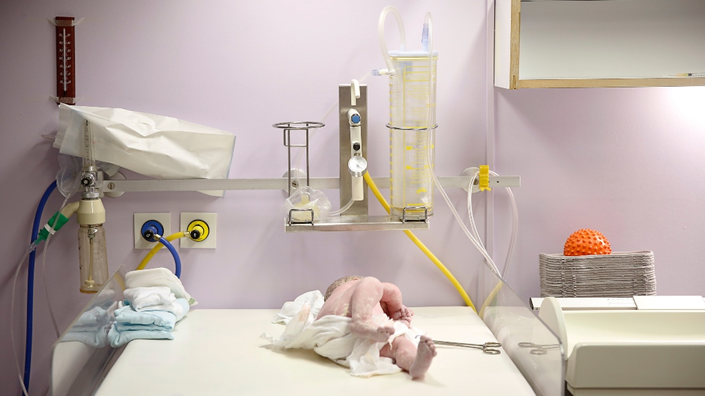 Maternity hospital delivery room, baby being assessed for apgar score