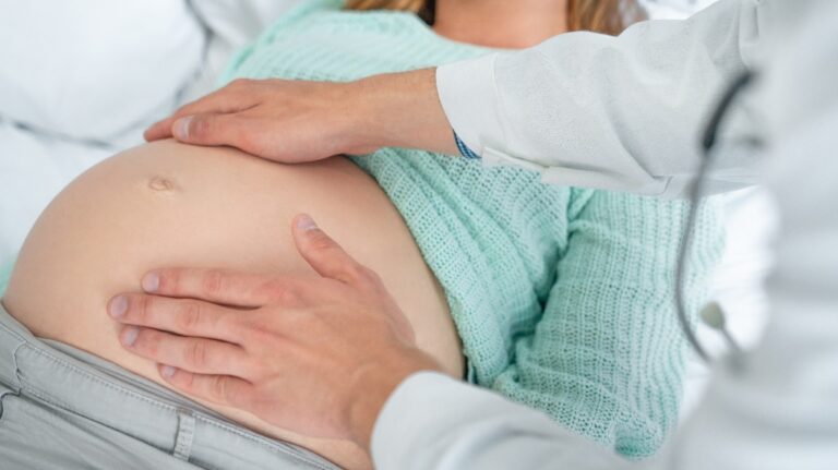 Close up shot of male doctor examining pregnant woman
