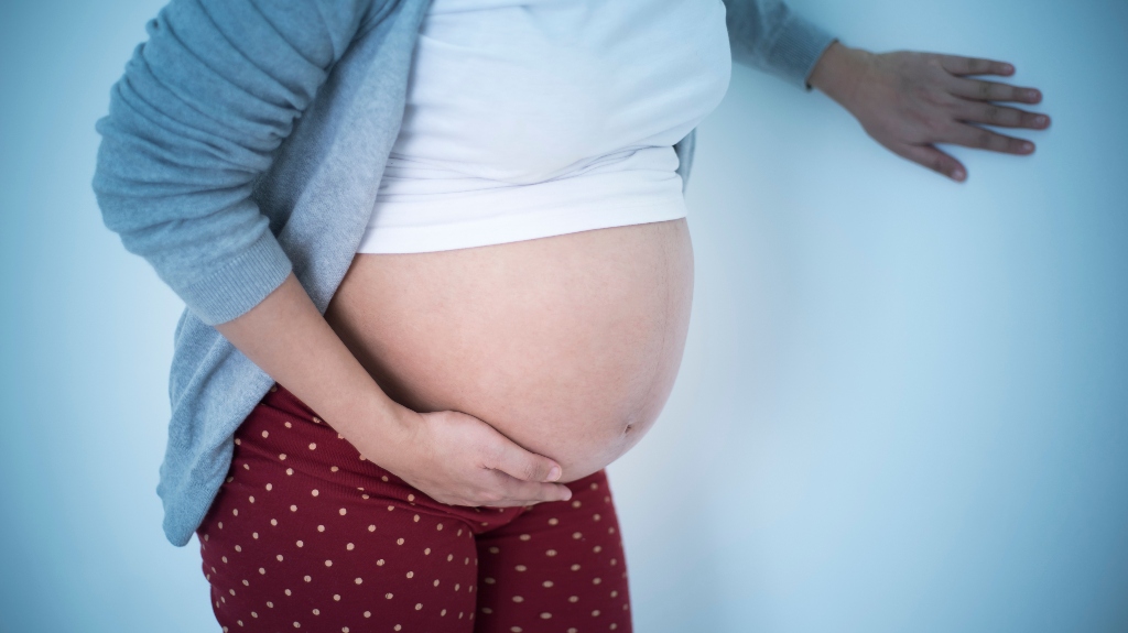 Pregnant woman touching belly and feeling pain
