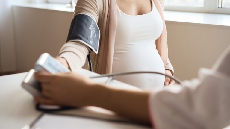 Doctor measuring blood pressure of her pregnant patient